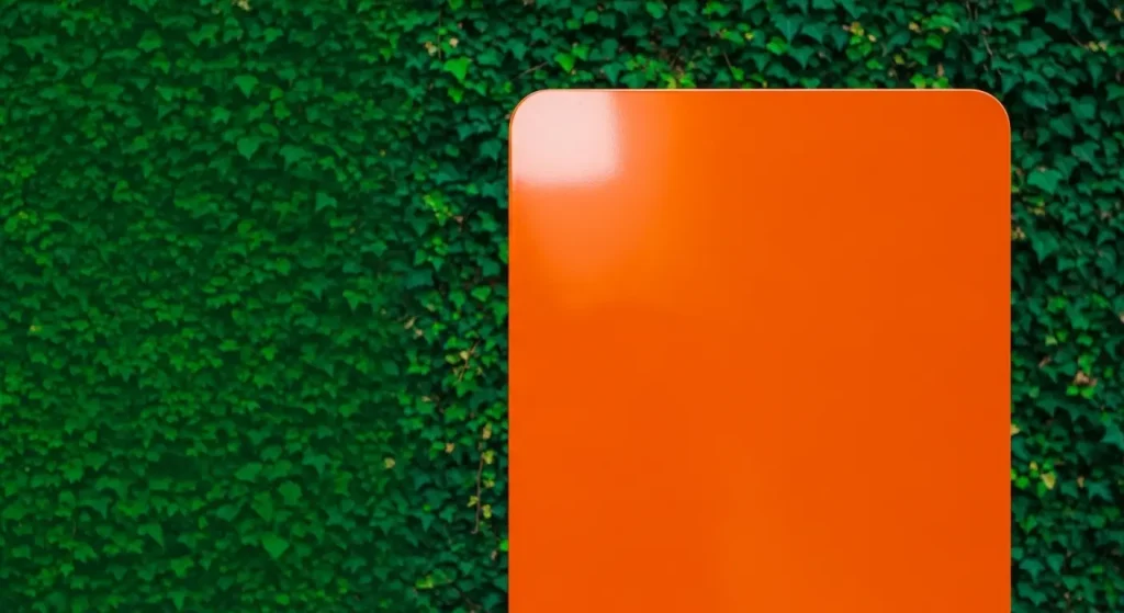 オレンジ色の看板が緑の背景の中で際立って見える様子。